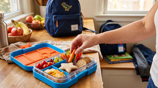 Packing a kids' lunchbox with colorful, healthy back-to-school snacks.