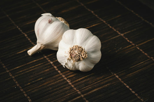 Fresh garlic bulbs and cloves on a wooden cutting board